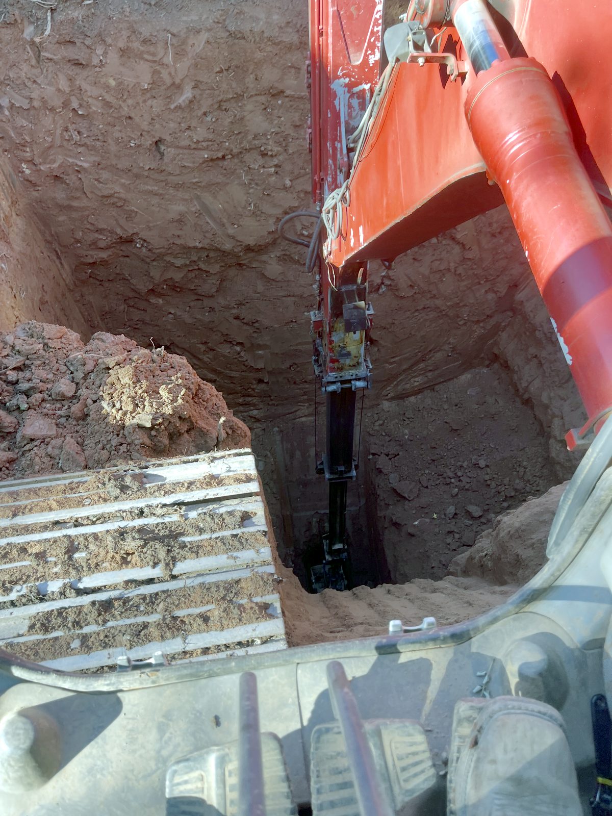 View from the excavator cab down a deep excavation